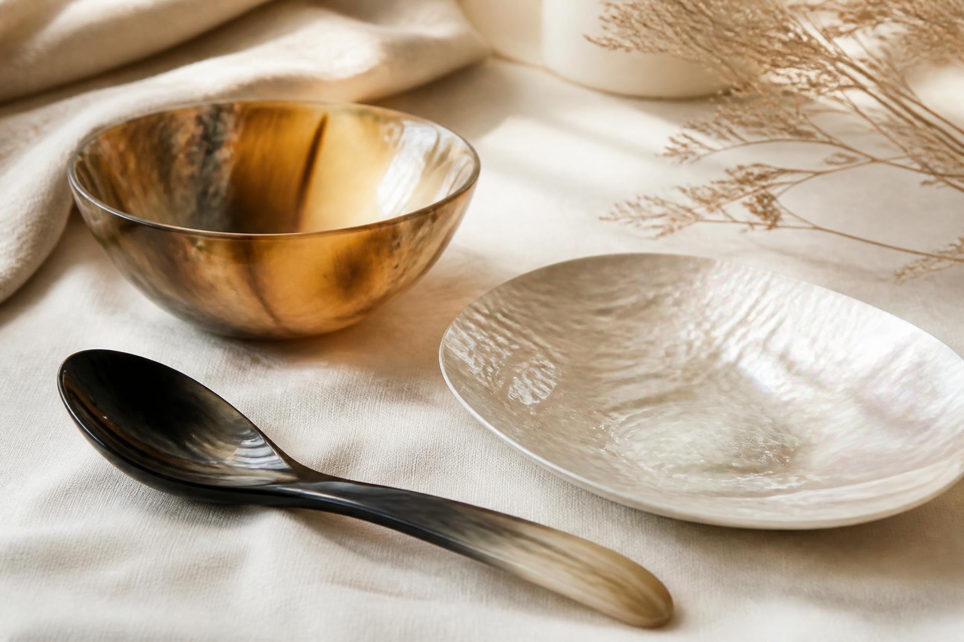 Buffalo horn and mother-of-pearl objects arranged on linen
